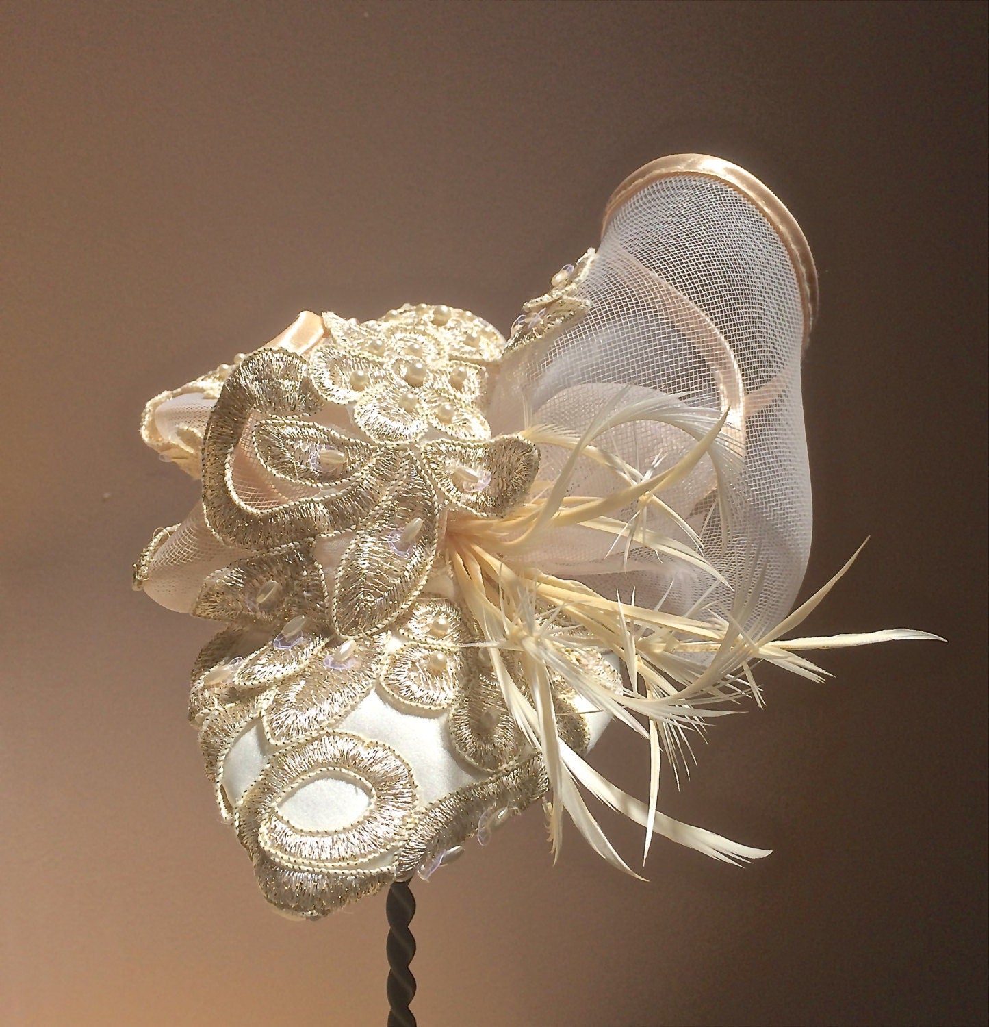 Ivory Embroidered Lace Fascinator with Gold Metallic threads and Pearls. Embellished with Feathers and Silk Trimmed Crinoline.