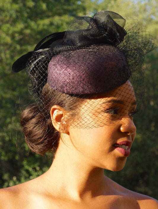 Aubergine Iridescent Leather pillbox. Perfect Ascot Derby Race Day. Hat with black crinoline, Black veiling and iridescent rooster feathers.