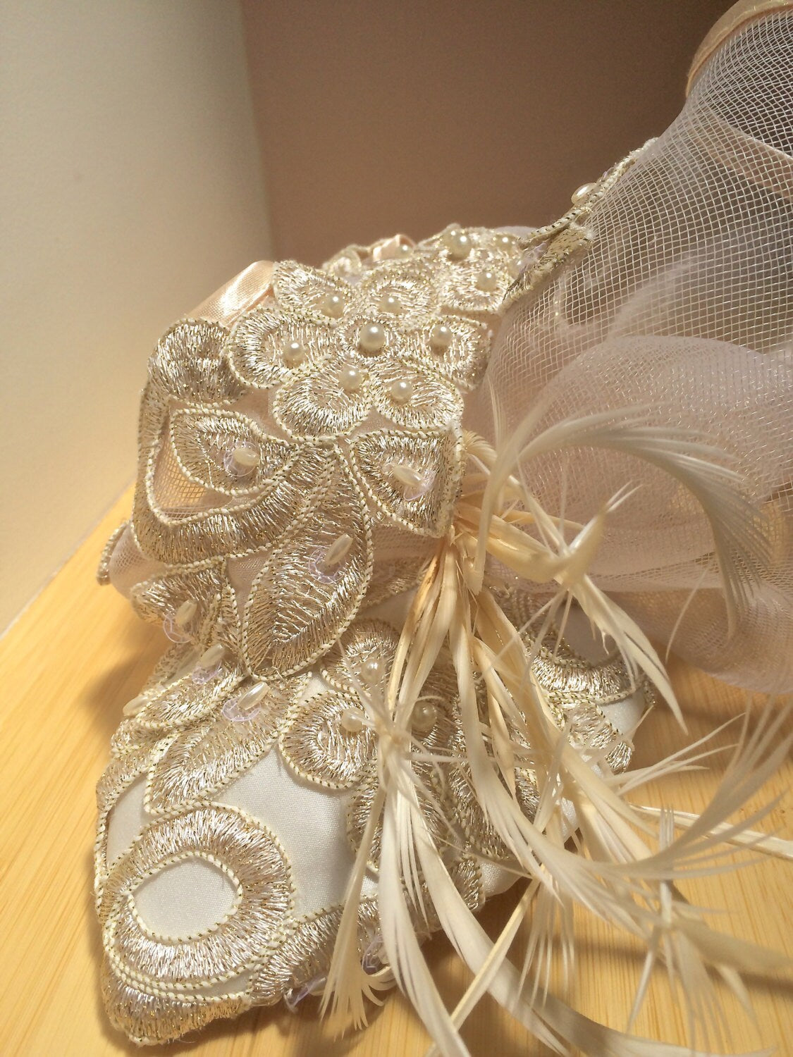 Ivory Embroidered Lace Fascinator with Gold Metallic threads and Pearls. Embellished with Feathers and Silk Trimmed Crinoline.